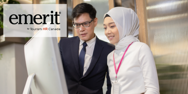 The image features two professionals working together while looking at a large screen. One person is wearing a suit and glasses, and the other is wearing a light-colored hijab with a pink lanyard. In the upper left corner, there is a logo for "emerit" by Tourism HR Canada. The setting appears to be an office environment.